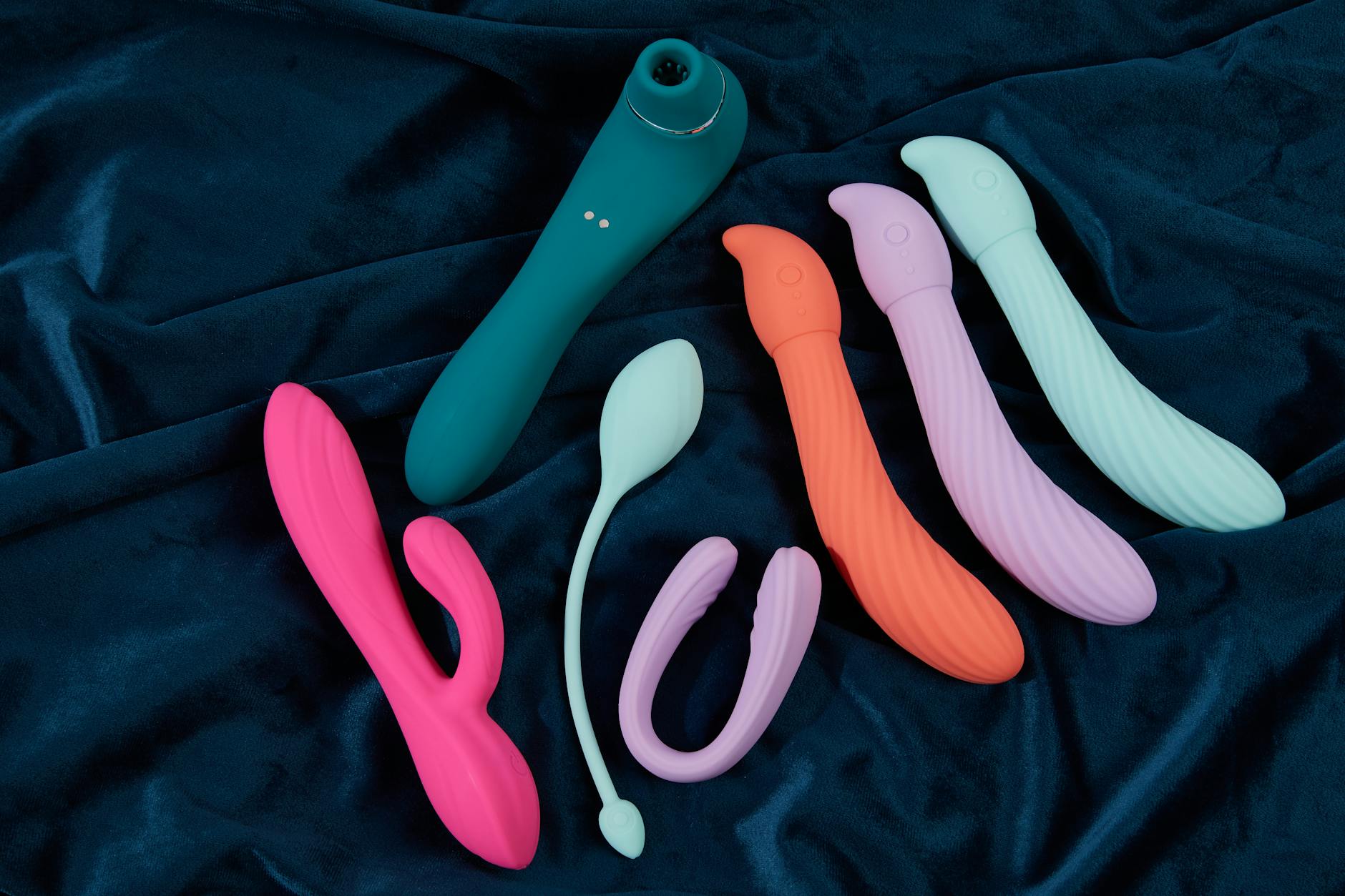 Woman holding silicone vibrators in a thoughtful pose