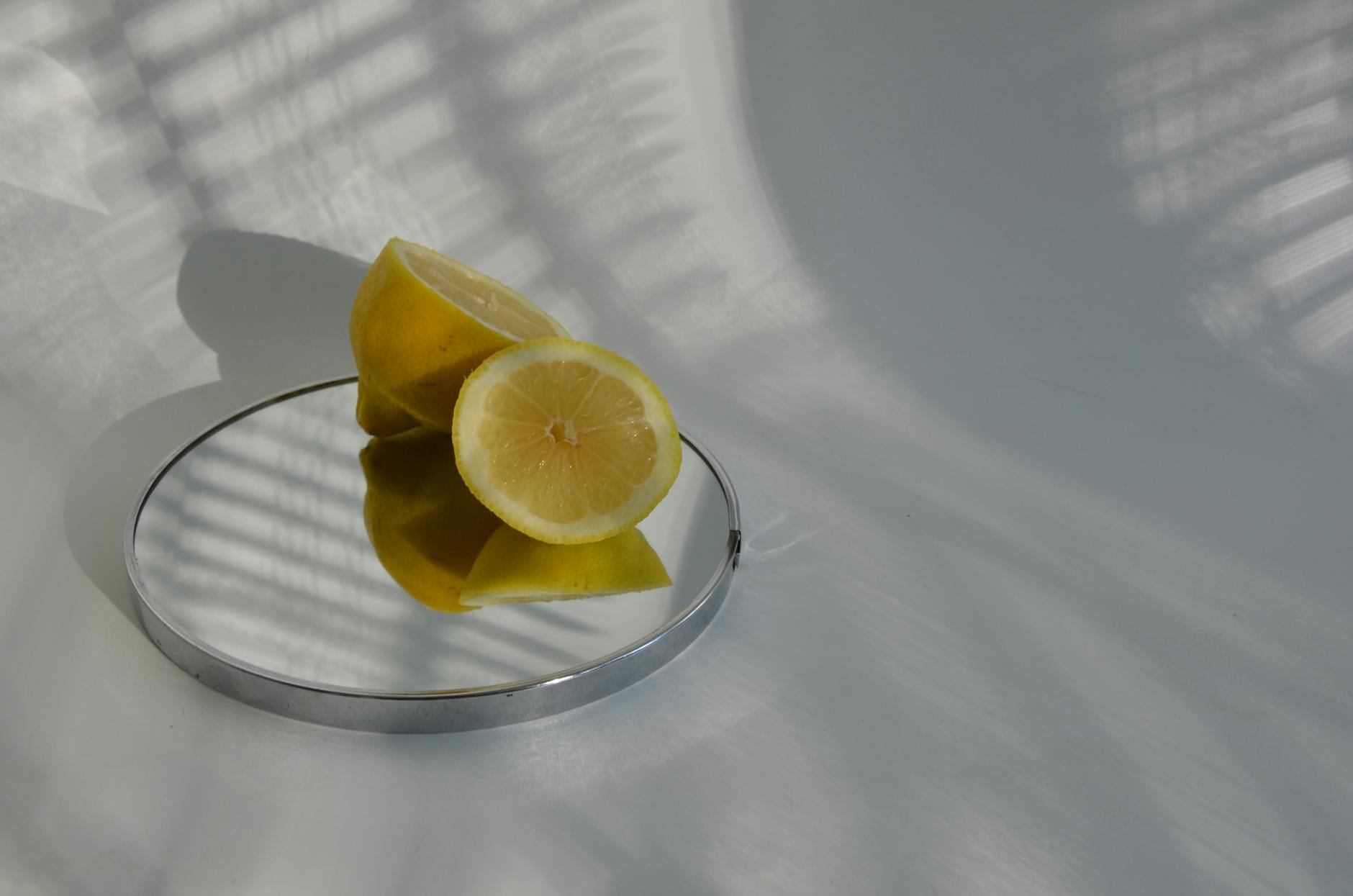 Close-up of a hand holding a lemon vibrator against a minimalistic purple backdrop