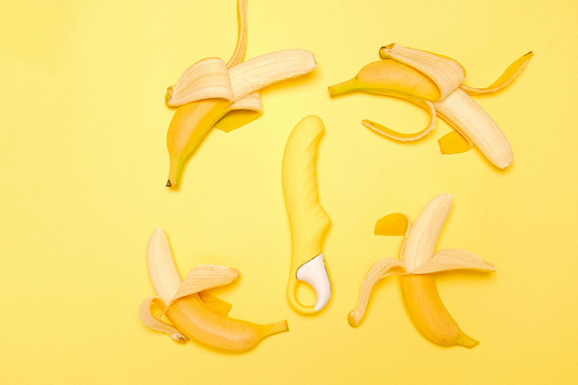 Vibrador Lemon amarillo rodeado de frutas frescas en fondo amarillo brillante