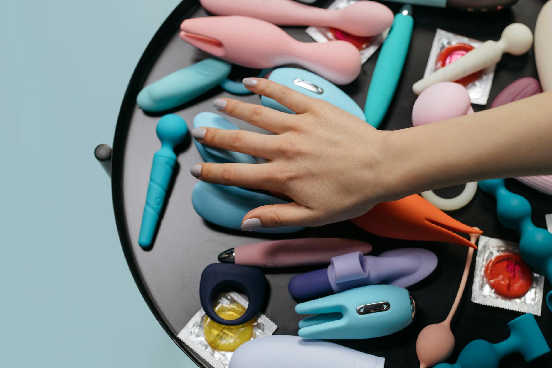 Woman holding colorful vibrators, representing options for comfortable pleasure