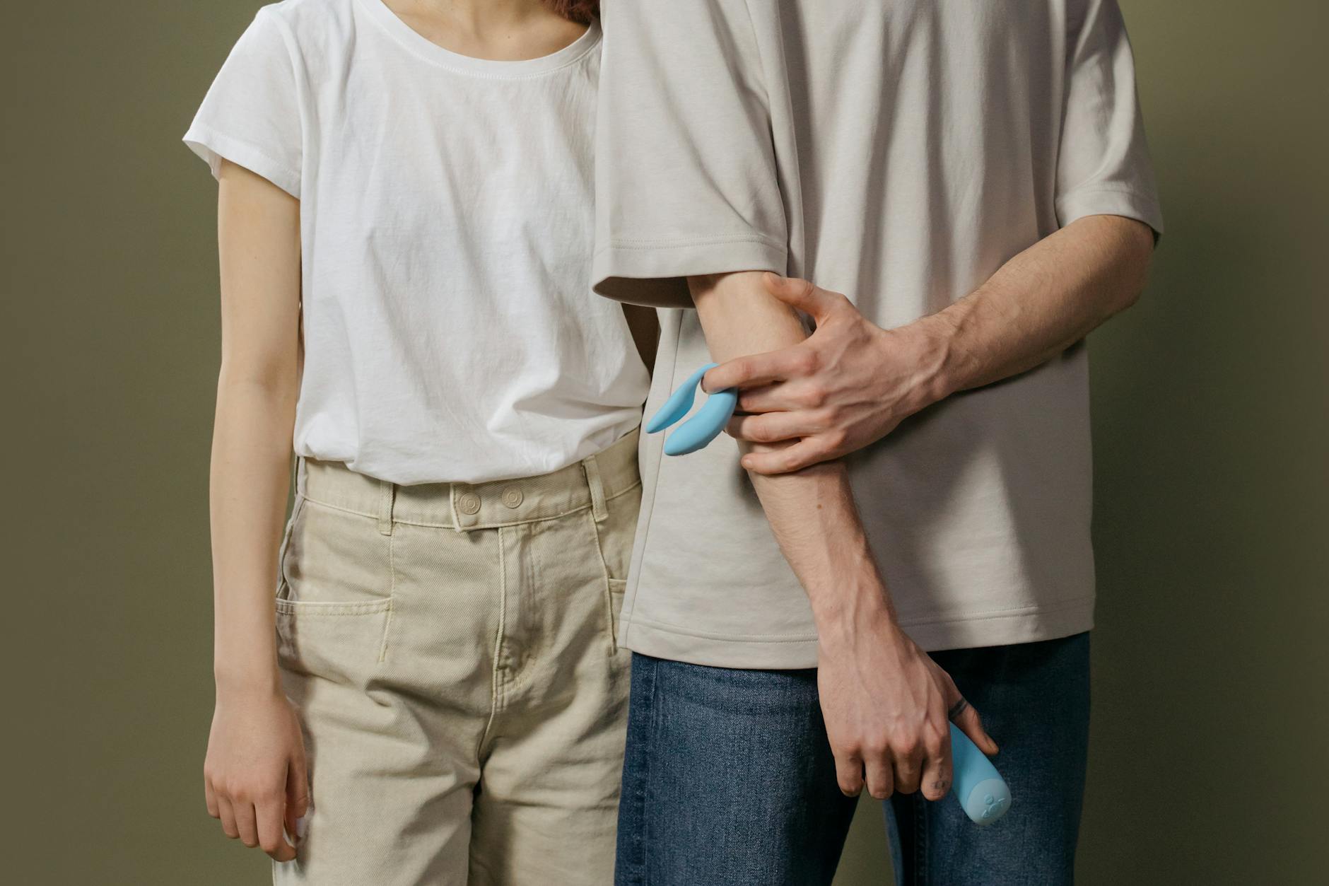 A couple holding a vibrator together, demonstrating open communication about pleasure in a new relationship